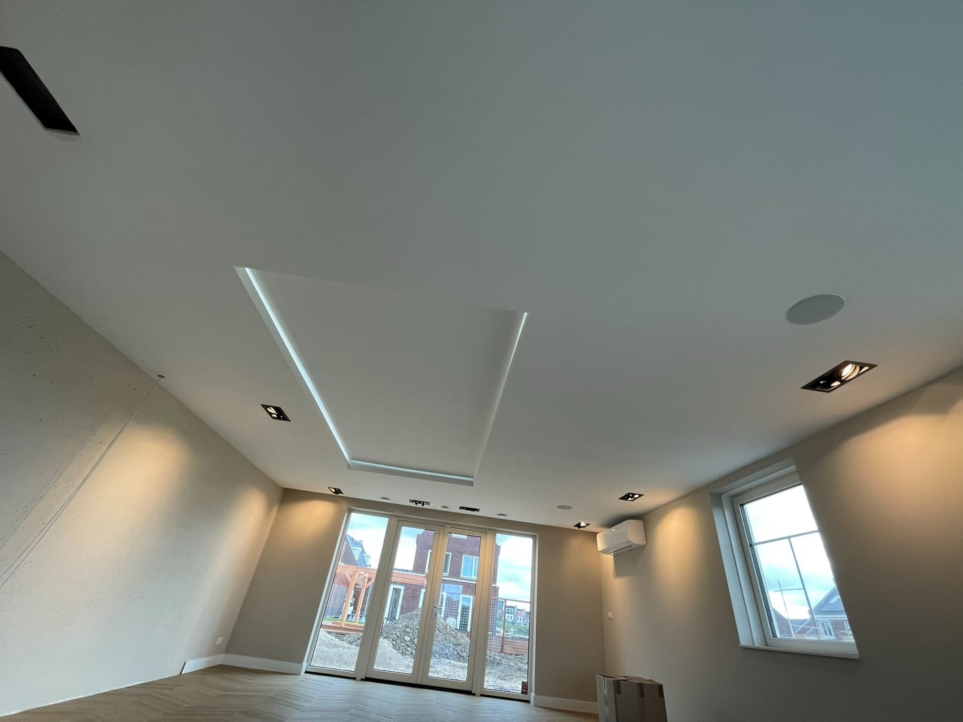 Afgewerkte kamer met een verlaagd plafond en een verlicht kader